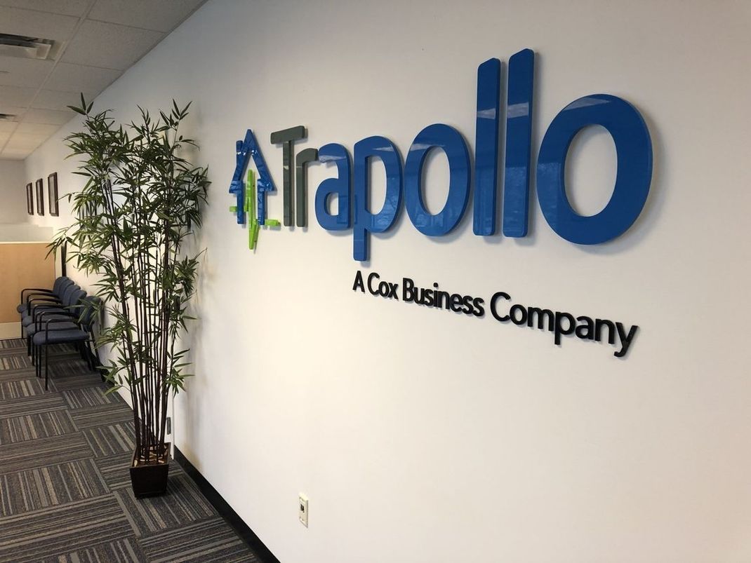 Office hallway with Tapolio A G Business Company wall sign and potted plants