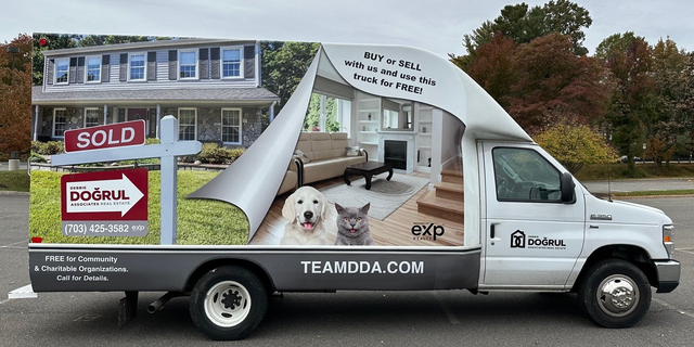 Real estate truck wrap with house, dog, and sold signs advertising teamdda.com