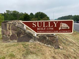 Sully historic park entrance sign with stone base and red panel, Fairfax County Park Authority