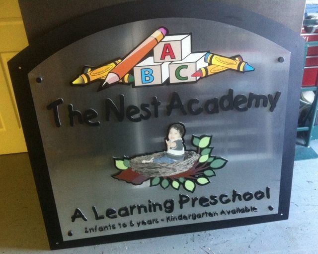 Sign for The Nest Academy, a learning preschool, with colorful school supplies and a bird nest logo