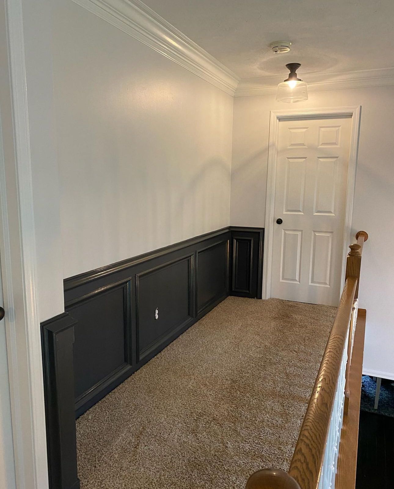 A hallway with a staircase and a door in a house.