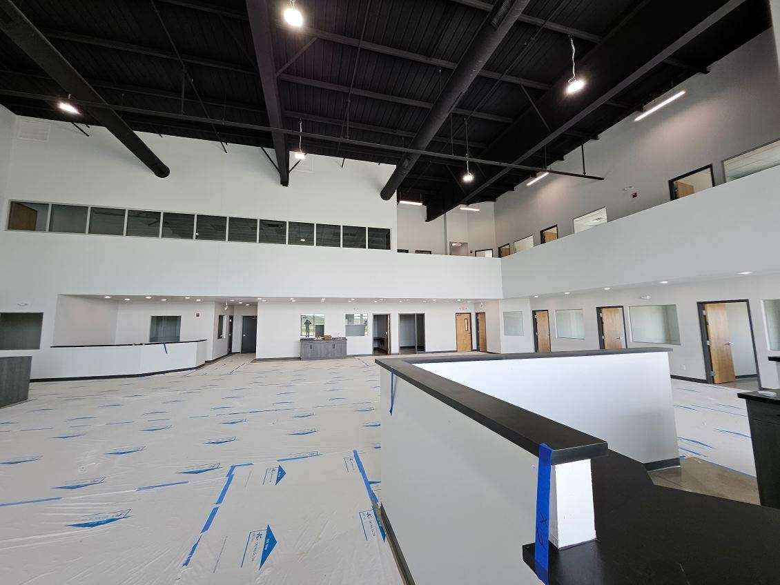 A large empty room with a lot of windows and a black ceiling.