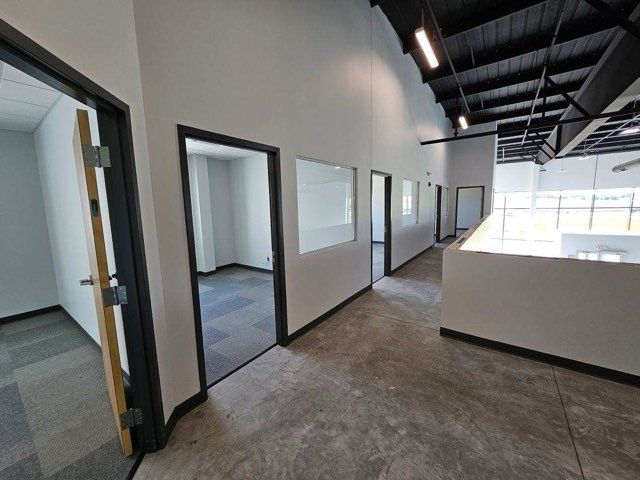 A long hallway with a lot of doors and windows