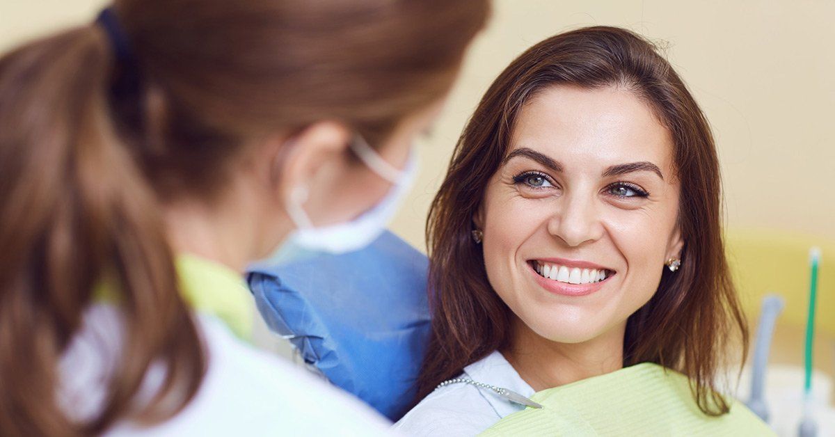 Woman smiling at dentist in dental office.