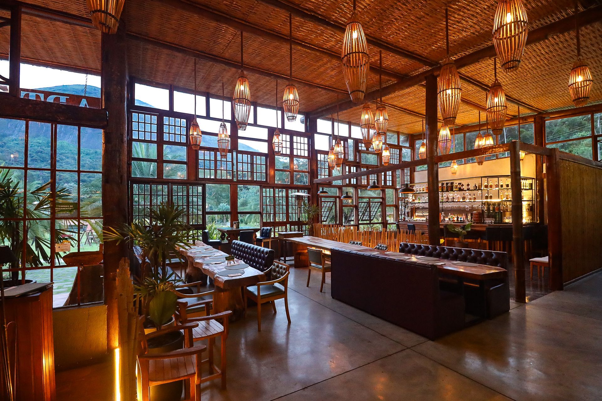 Entrada do restaurante ART CUCINA com luzes aconchegantes e duas pessoas em pé na porta.