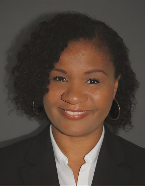Agency owner Padricia Benjamin in a suit and white shirt smiles for the camera