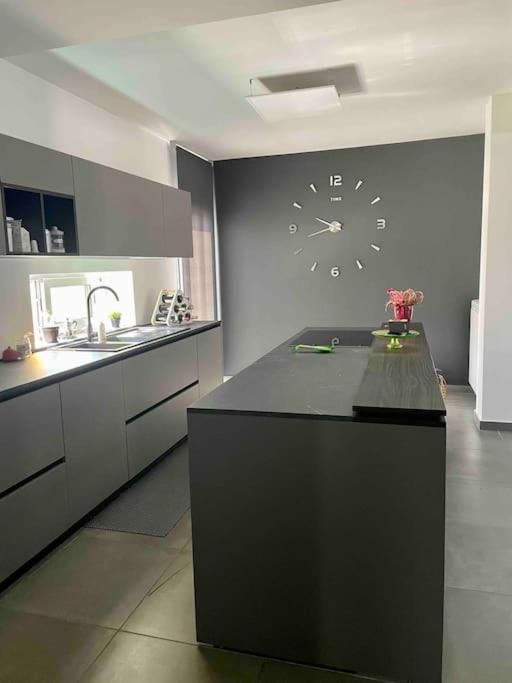 Una cucina con una grande isola e un orologio a parete.