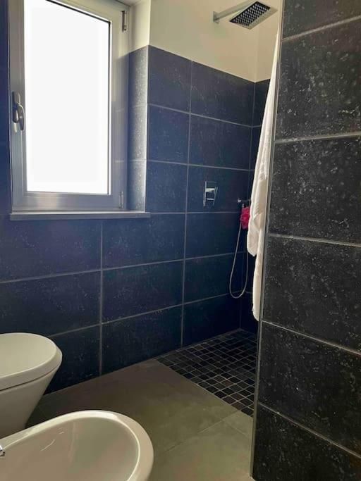 Un bagno con wc, bidet, doccia e finestra.