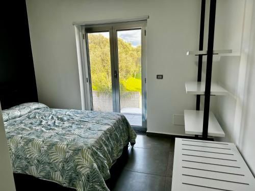 Una camera con un letto e una porta scorrevole in vetro.