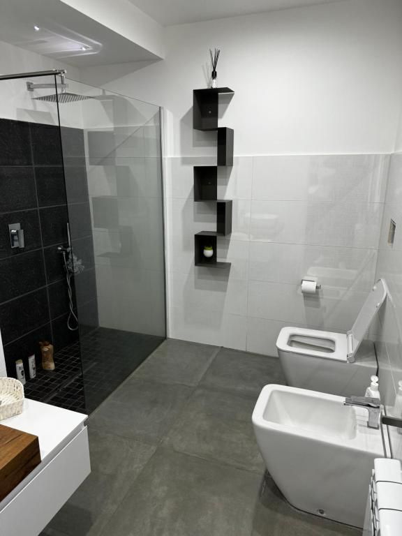 Un bagno con due WC, bidet e cabina doccia.