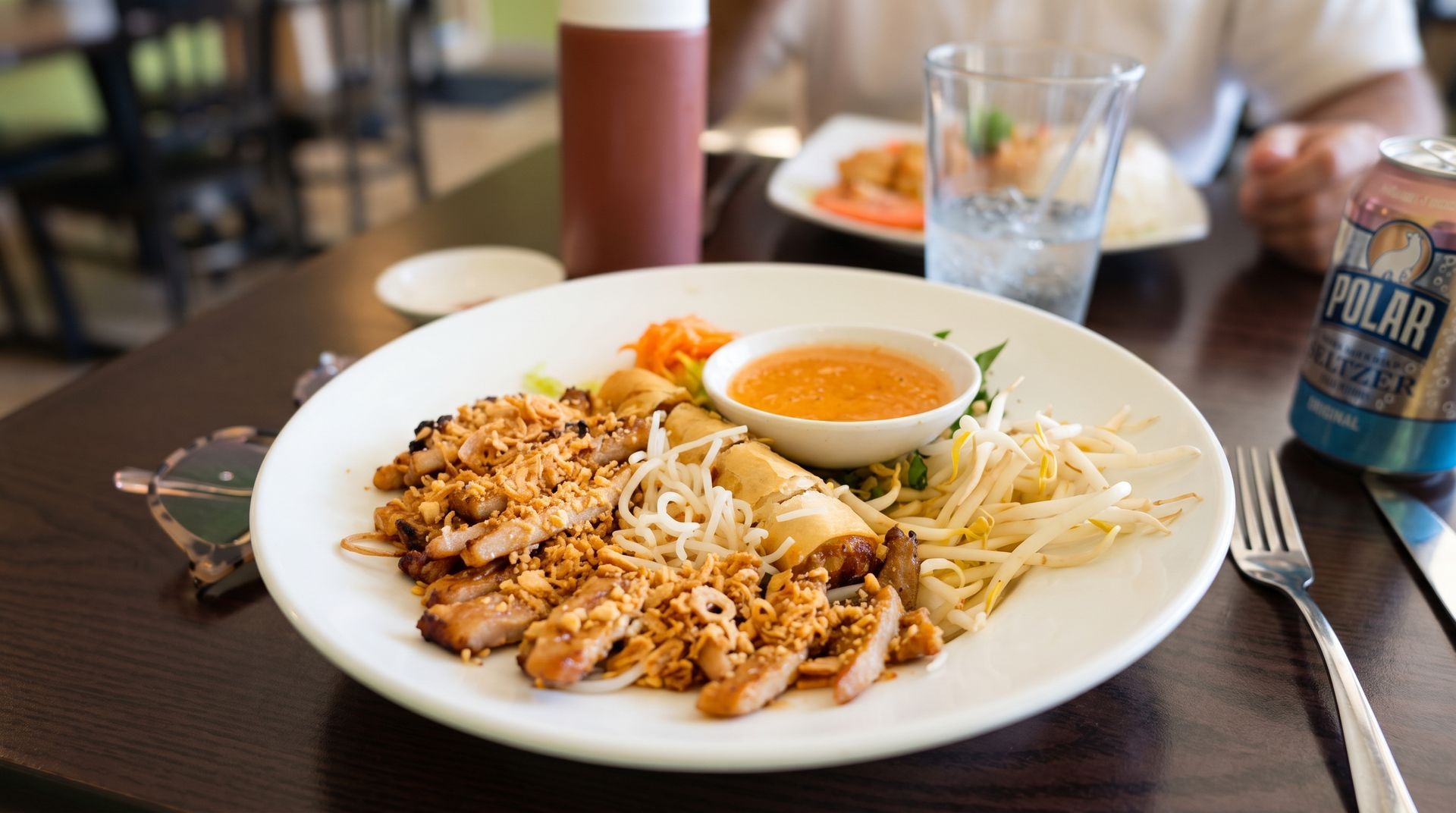 Plated rice dish with sliced meat, salad, and a soft-boiled egg on a restaurant table