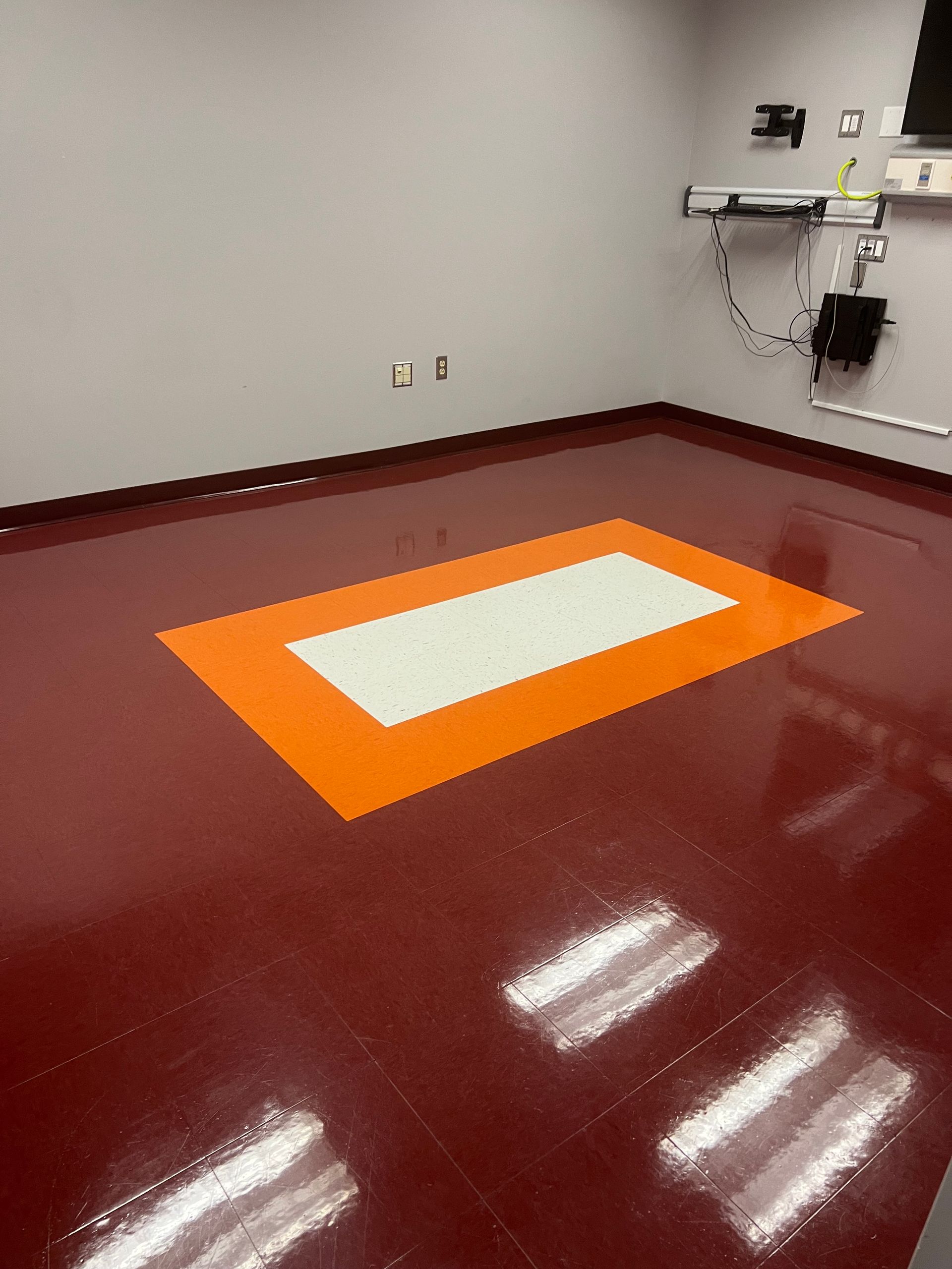 A red floor with a white and orange square on it.