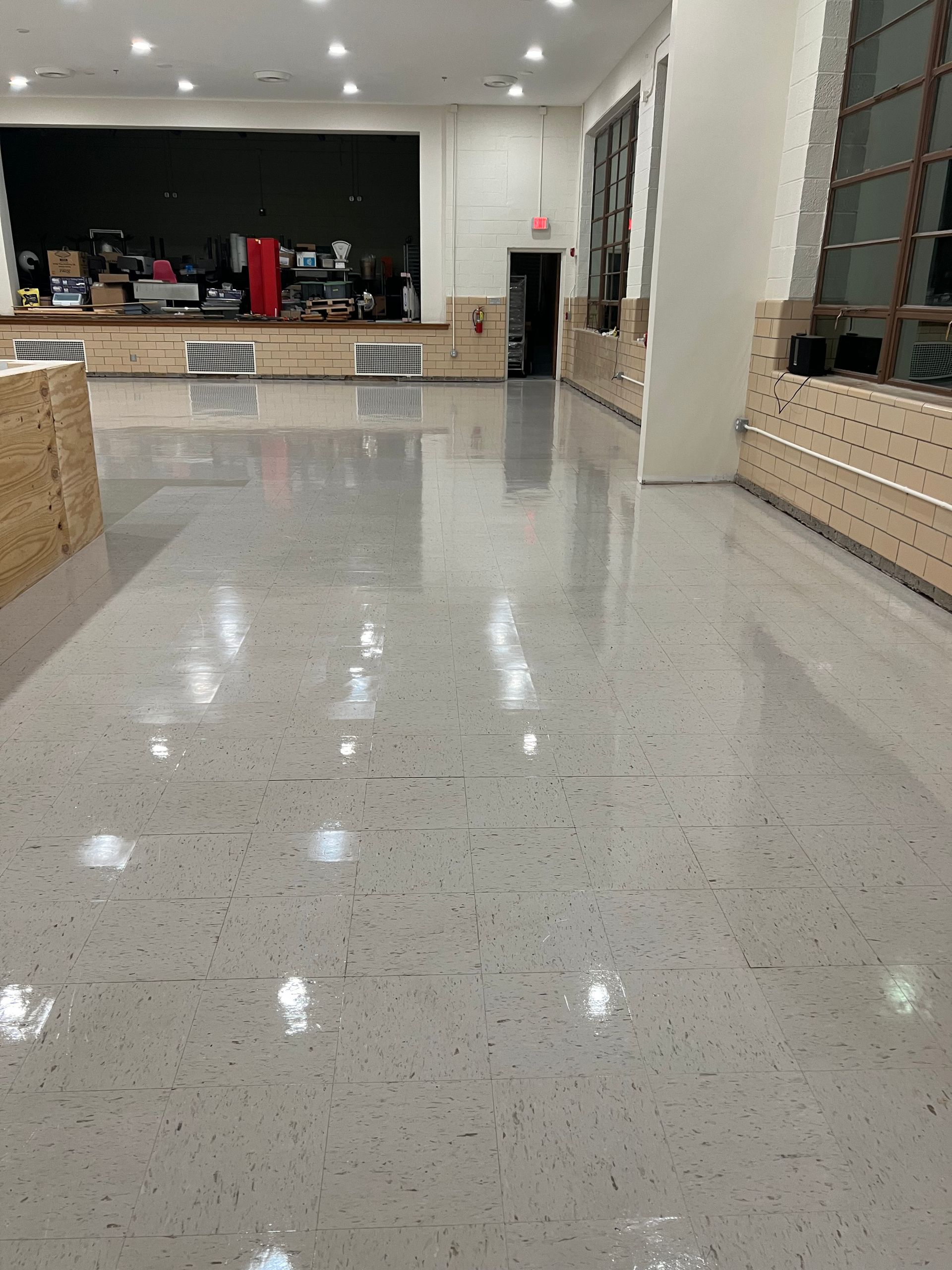 A large room with a shiny floor and a stage in the background