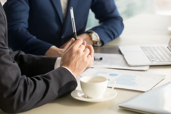 two businessmen discussing analyzing financial data