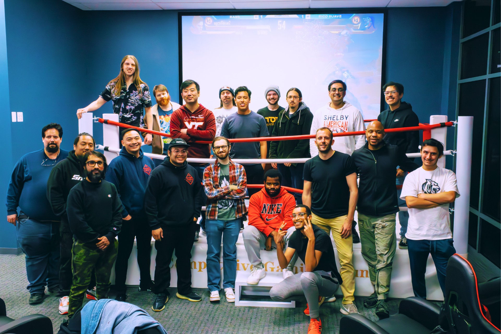 A group of people are posing for a picture in a boxing ring.