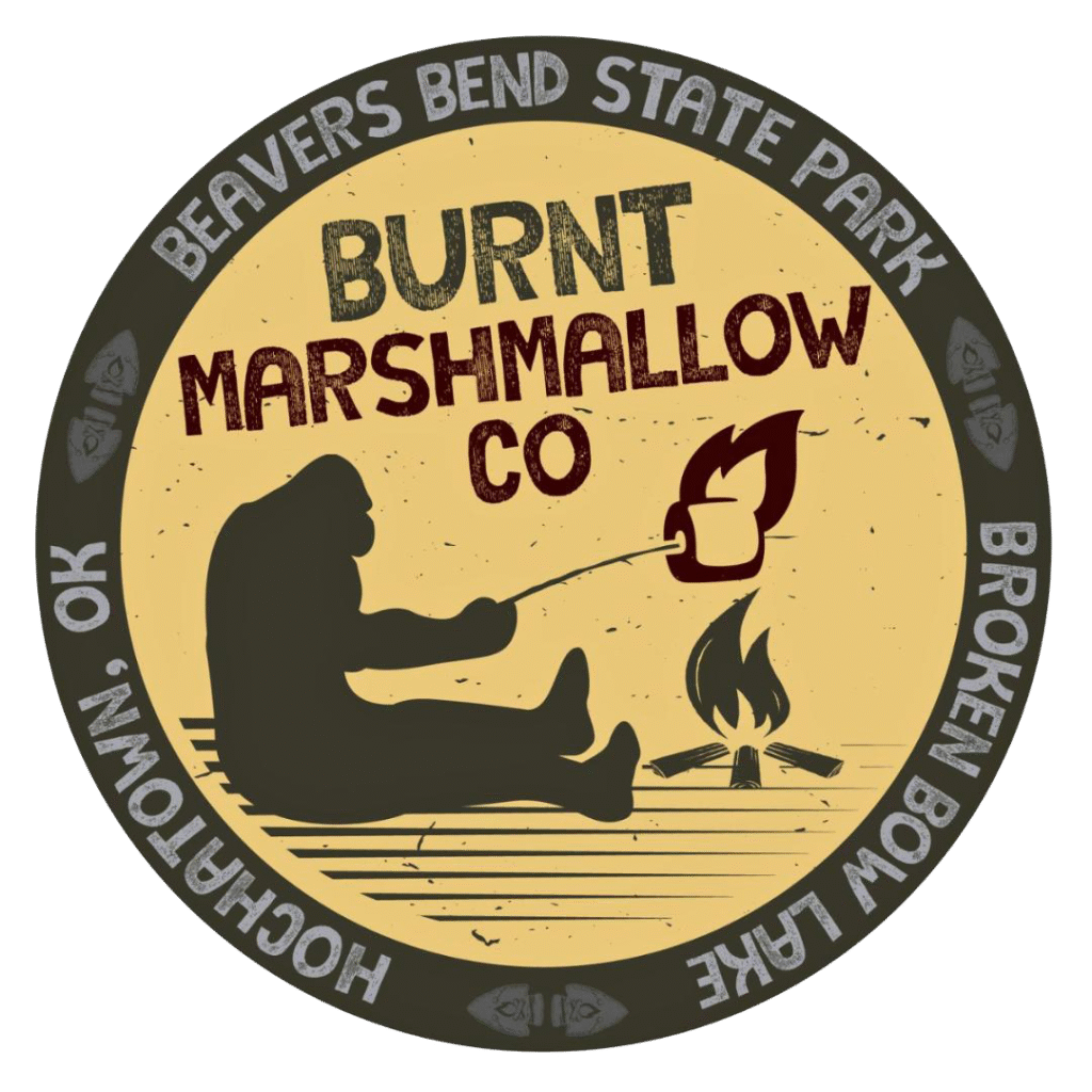 Burnt Marshmallow Co. logo with silhouette by a campfire inside Beavers Bend State Park emblem