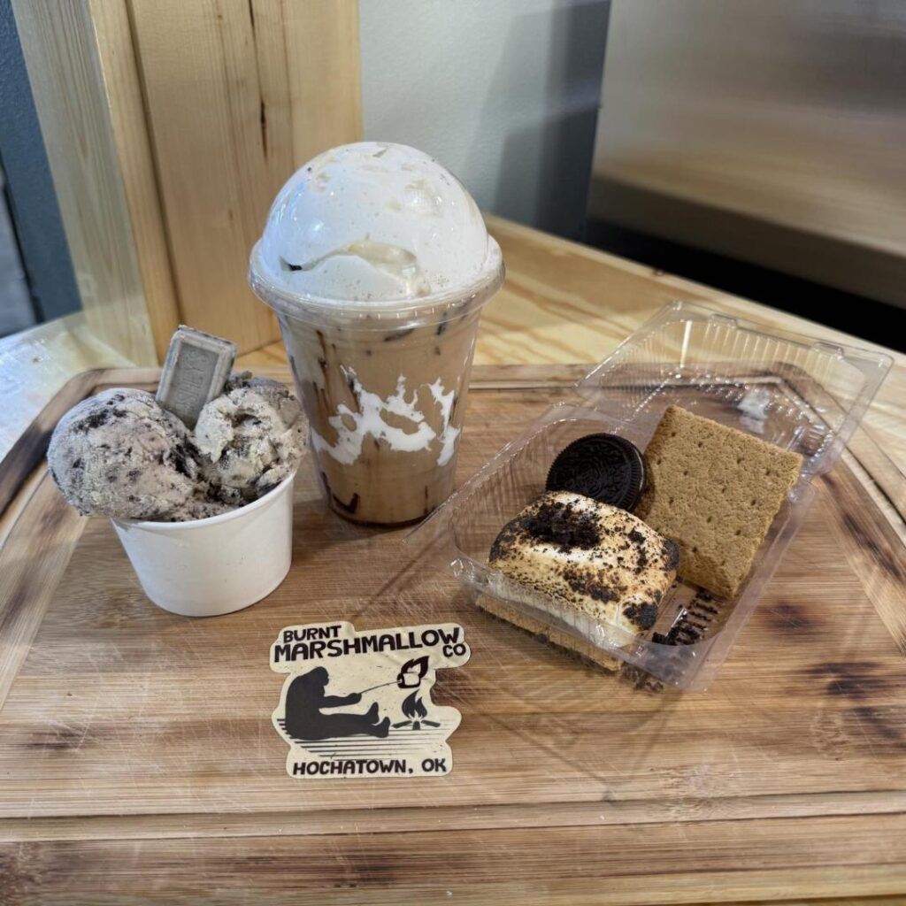 Three marshmallow-themed desserts and a whipped cream drink on a wooden tray