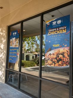 Storefront windows with blue fried chicken posters advertising spicy chicken and combo meals