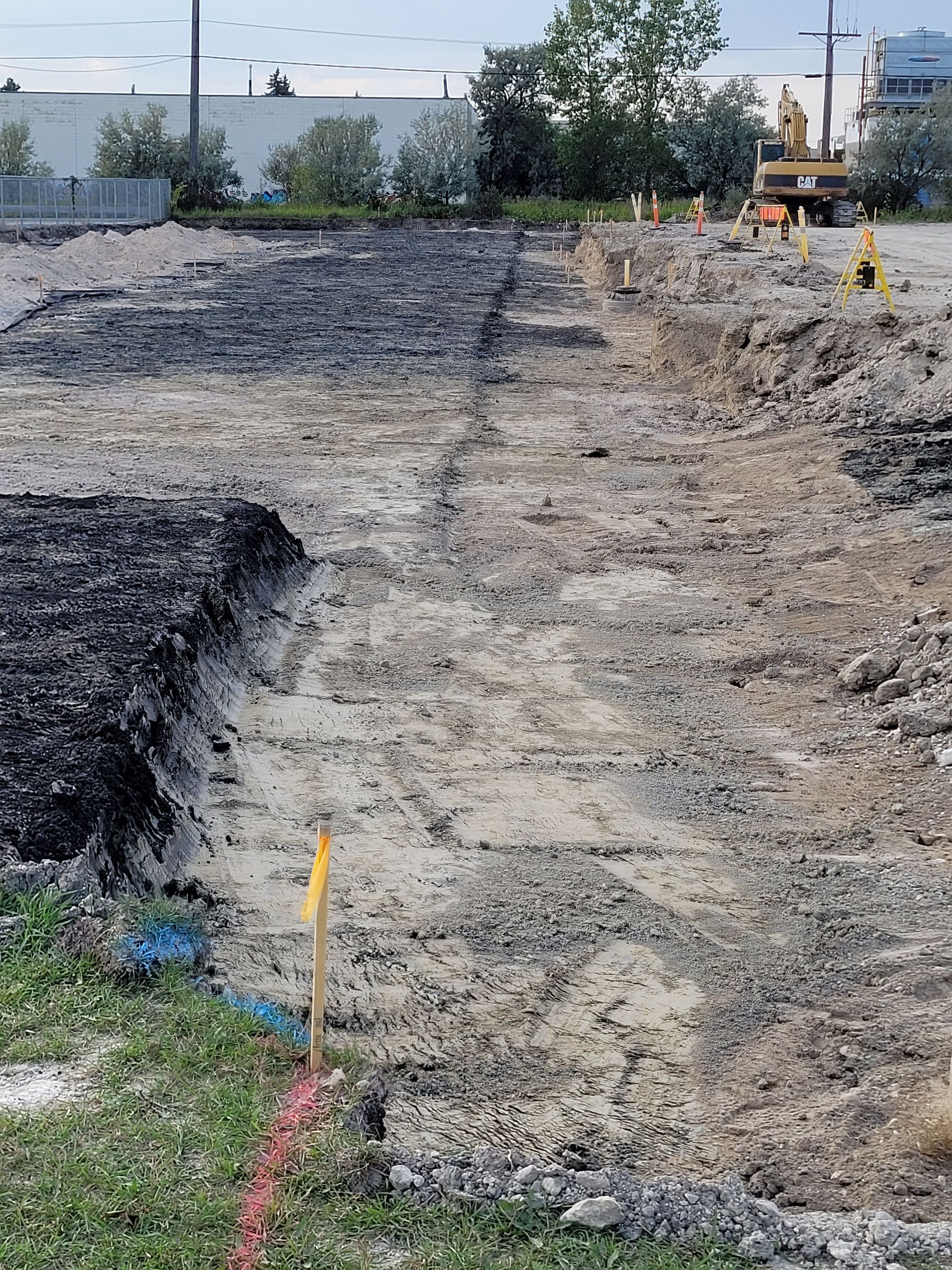A construction site with a lot of dirt and a bulldozer in the background.