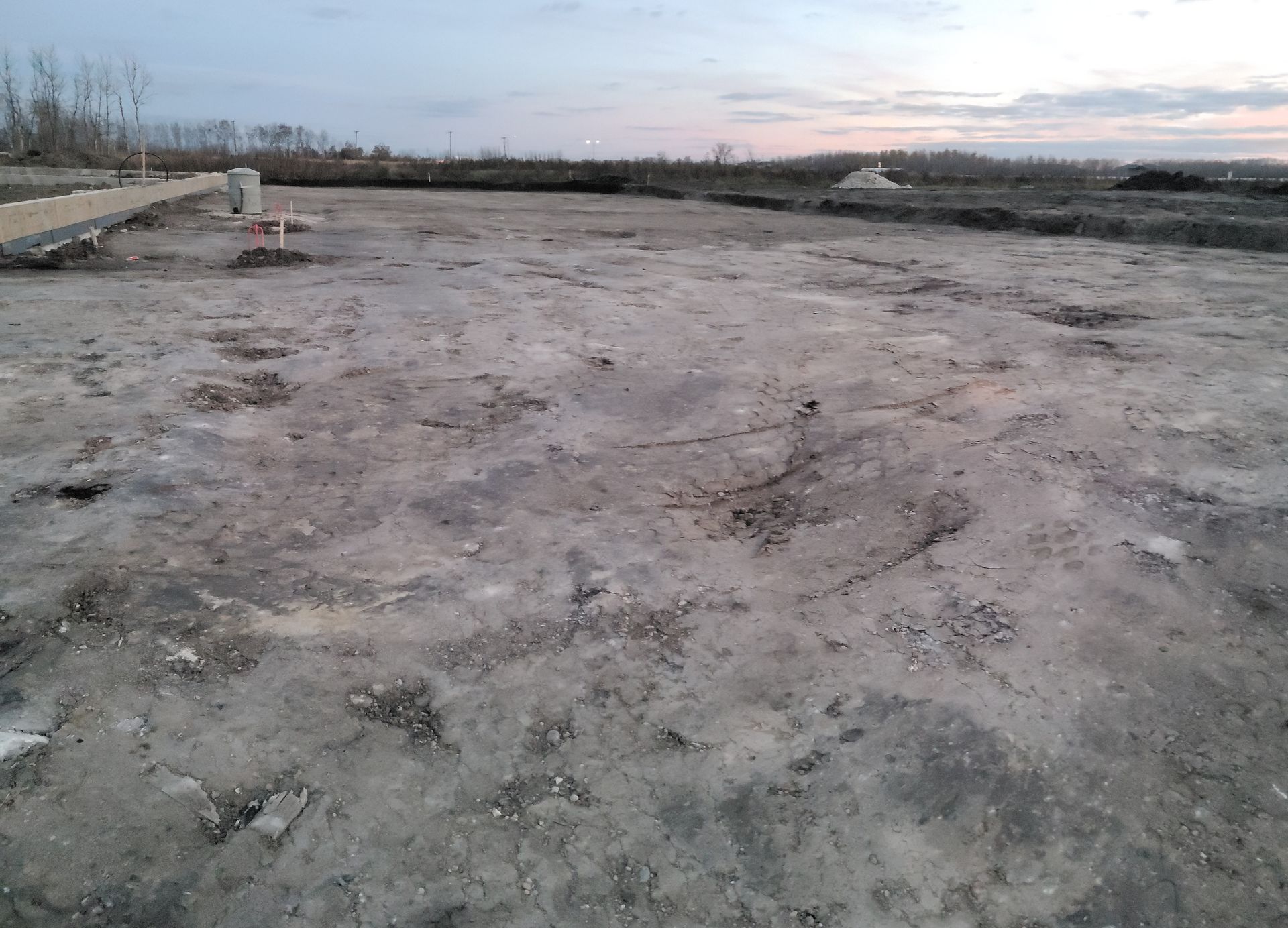 A large empty dirt field with a sunset in the background.