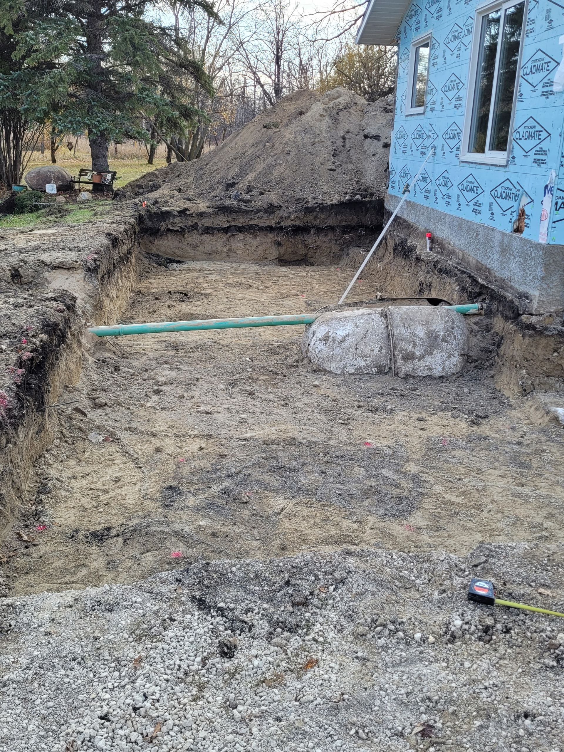 A large pile of dirt is sitting in front of a house.