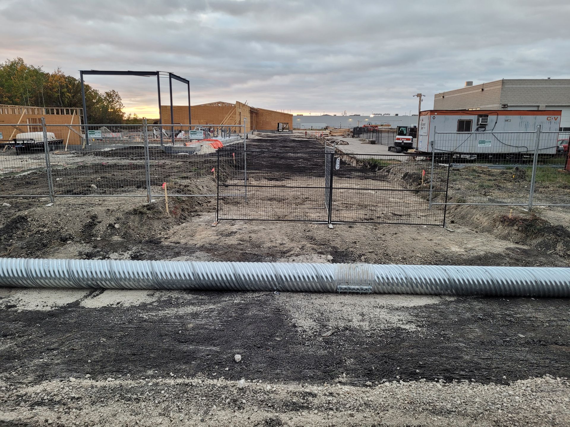 A large pipe is sitting in the middle of a dirt field.
