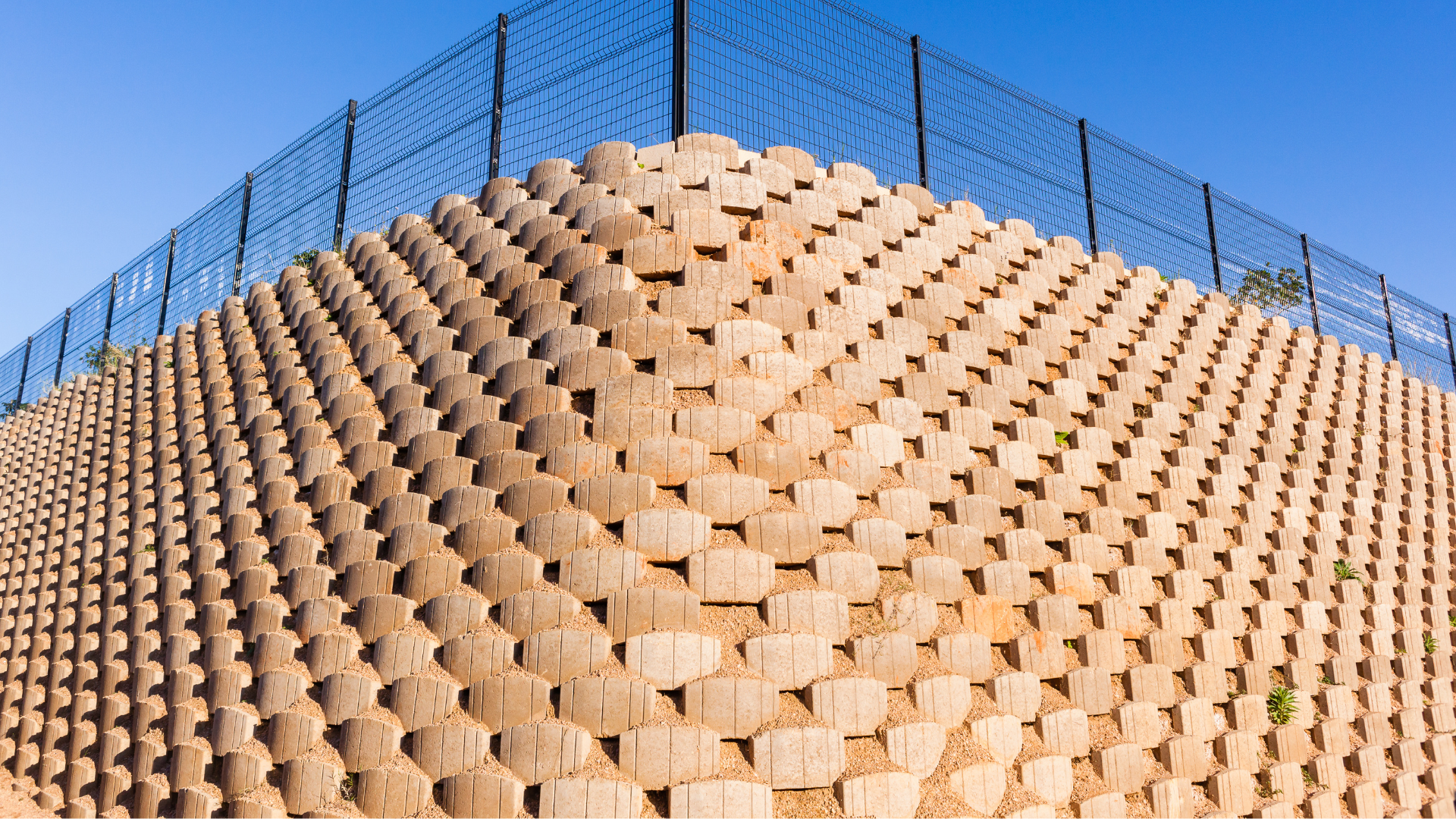 A large brick wall with a barbed wire fence surrounding it.