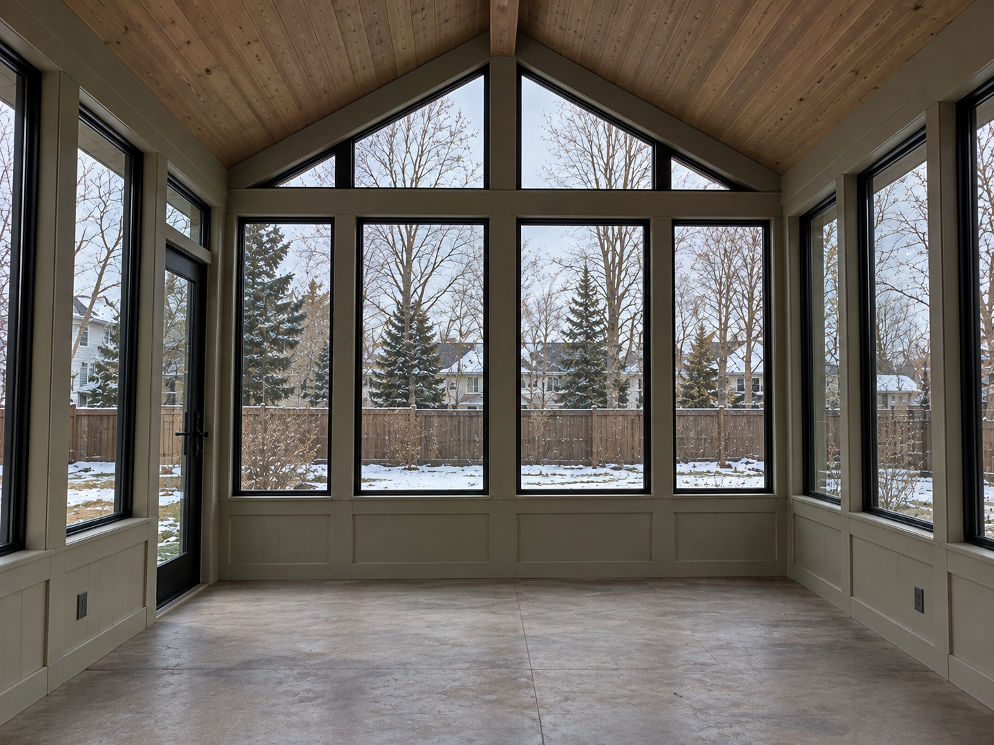 Inside a sunroom with a cedar vaulted ceiling, gable windows and a glass door built by Colorado Outdoor Builders in Aurora, Colorado