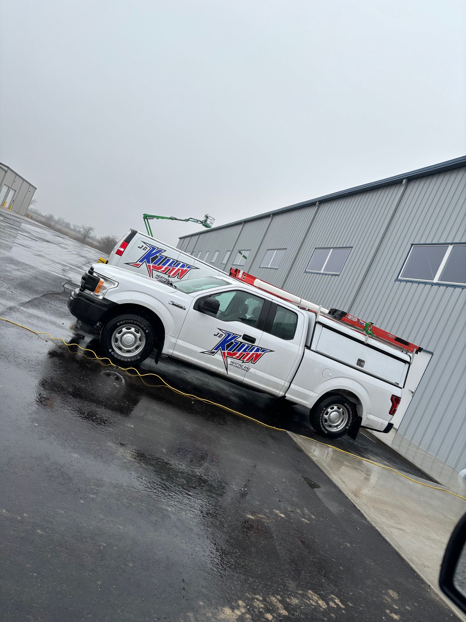 A white truck is parked on the side of the road in front of a building.