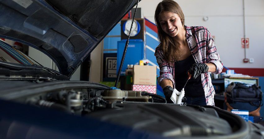 Women inspecting her vehicle before a road trip