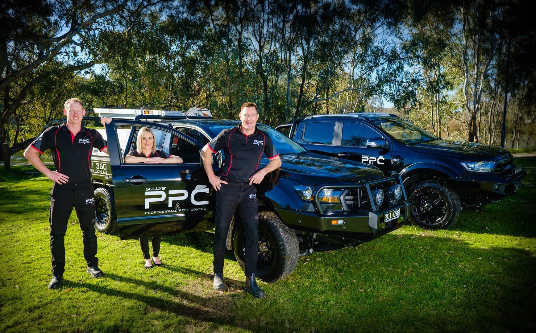 Staff standing with vehicles — Professional Pest Control In Albury Wodonga NSW
