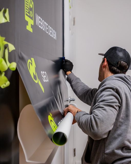 A man is wrapping a sign that says website design