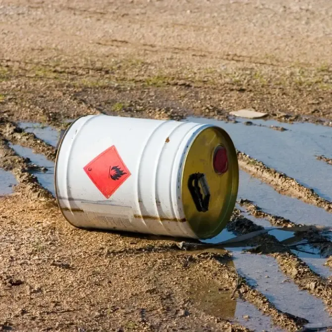 a white barrel with a red warning label on it