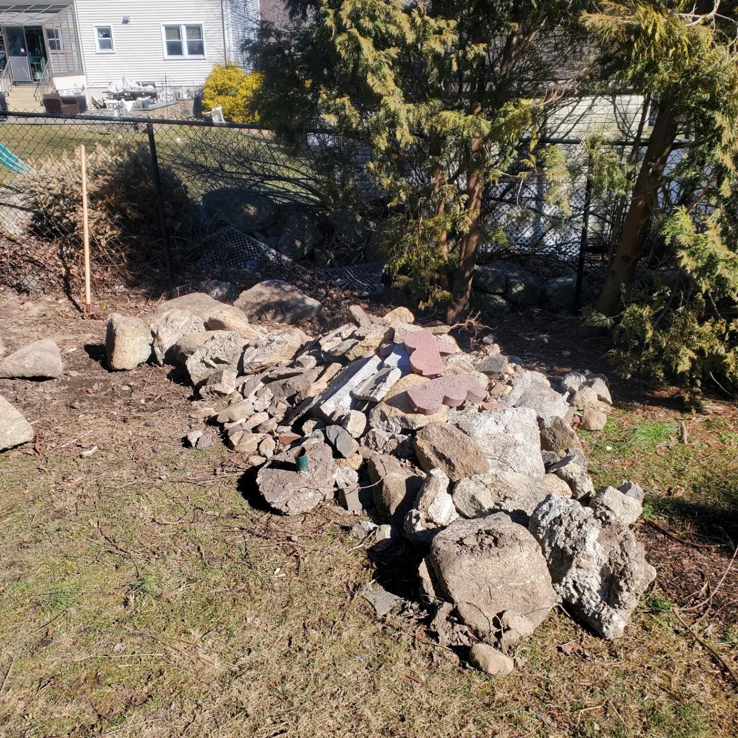 pile of rocks in yard, rock removal, yard debris removal