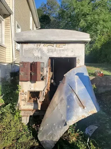 A large metal object is sitting in front of a house.