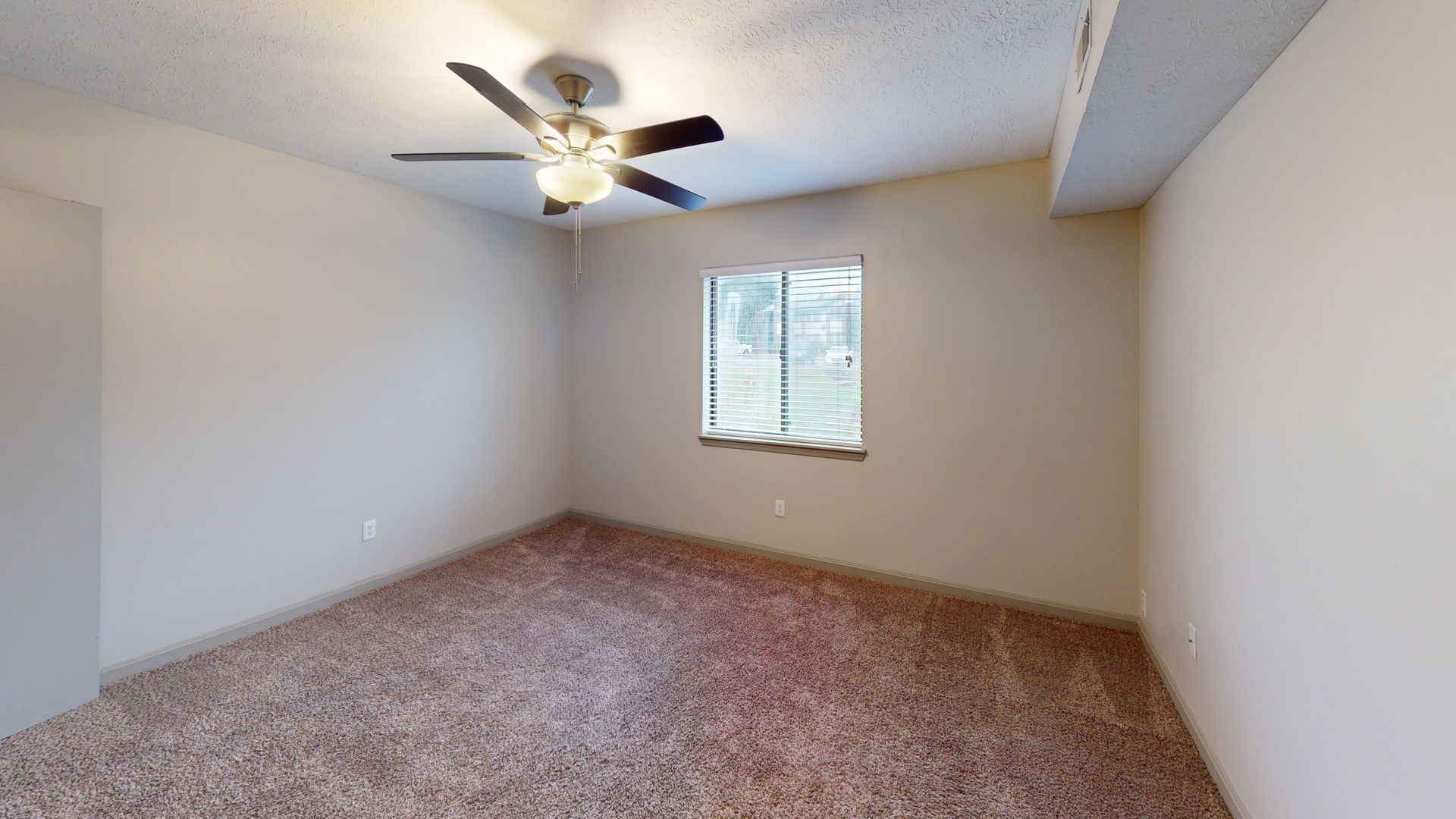 Bedroom featuring a fan and large windows