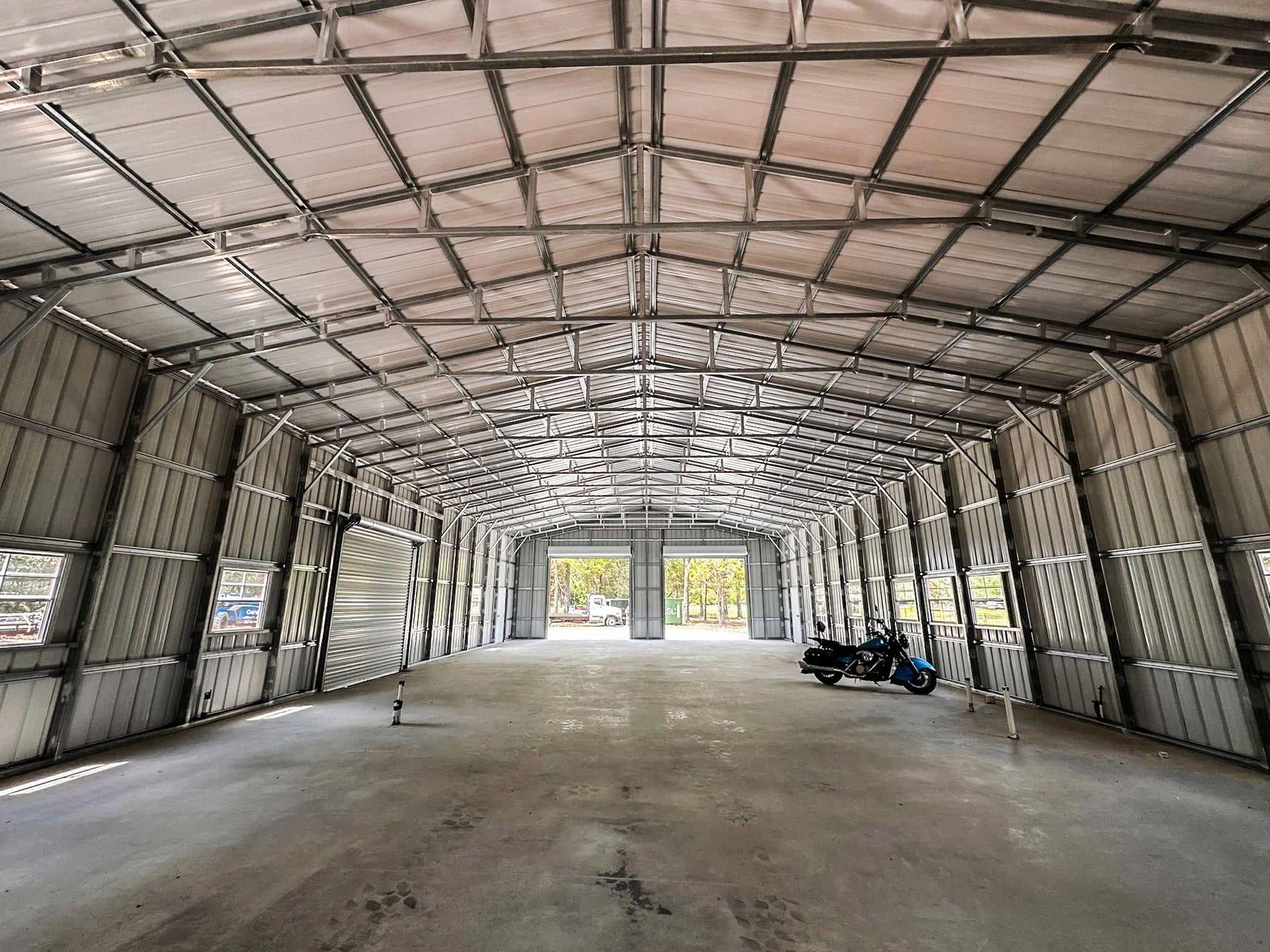 Interior of a wide-clearspan metal workshop with high eave height and auto lift
