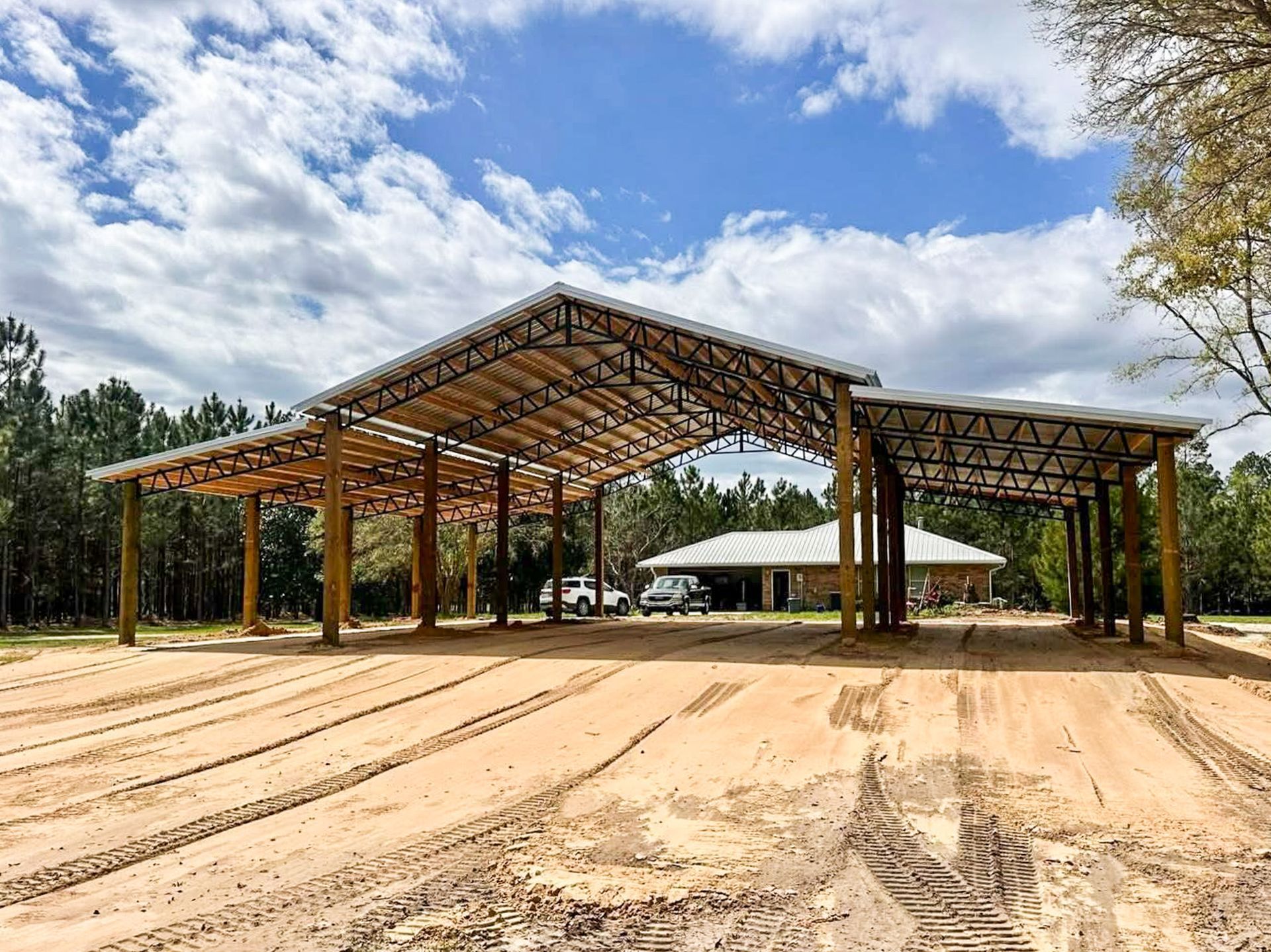 Metal horse barn interior with stall dividers and hay bales
