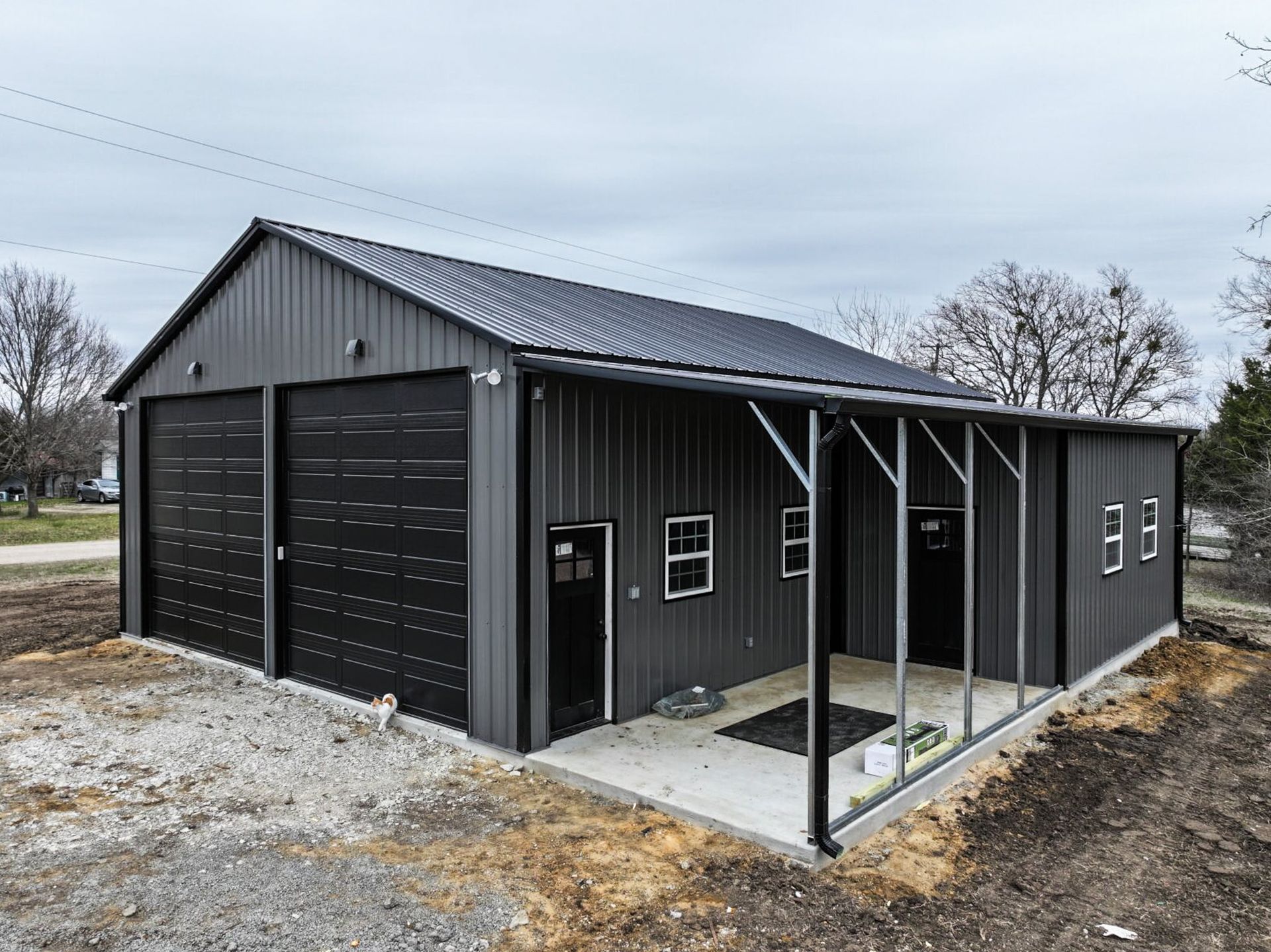 Garage with lean-to addition on gravel lot