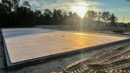 Cleared Florida rural lot with freshly poured concrete pad ready for installation