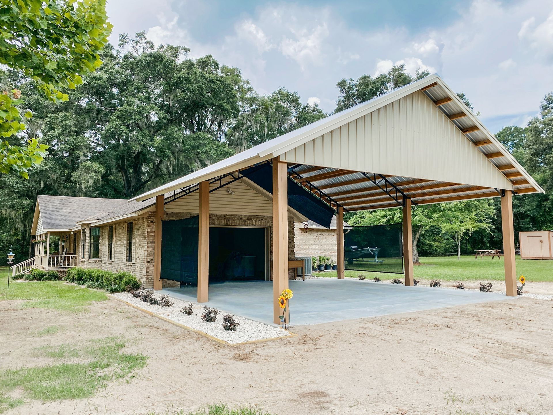 Double-wide metal carport sheltering a pickup truck and riding mower on a Florida property