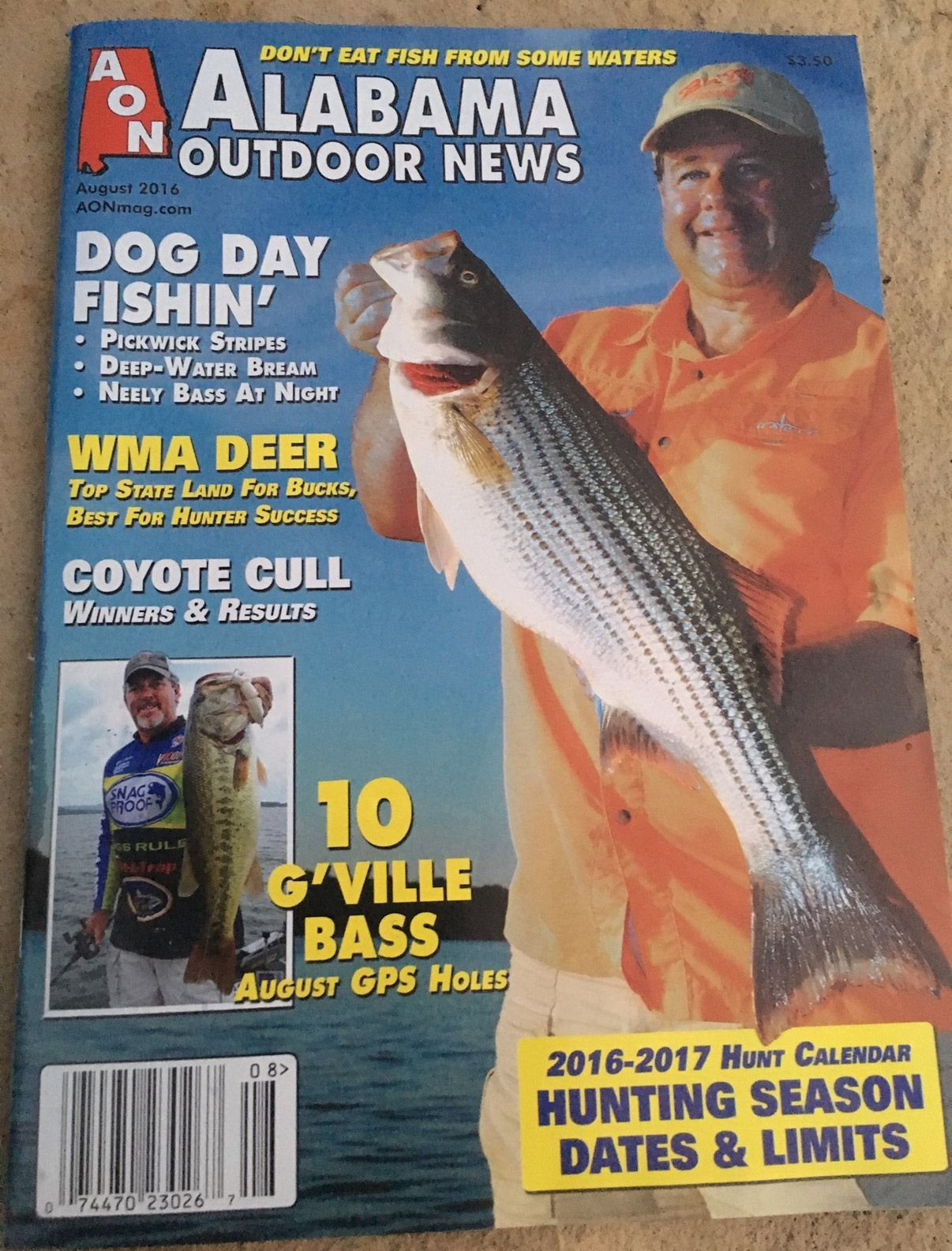 Alabama Outdoor News cover with angler holding a striped bass, blue background, fishing and hunting headlines | Pitts Automotive