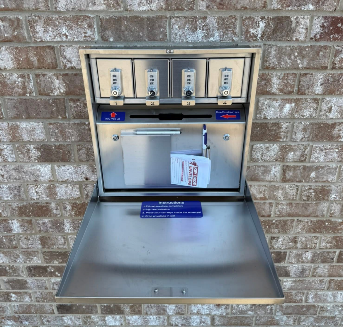 Outdoor stainless steel pet waste station mounted on a brick wall with bag dispensers and trash bin | Pitts Automotive