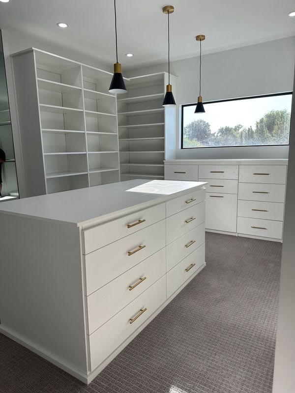 A walk in closet with lots of drawers and shelves