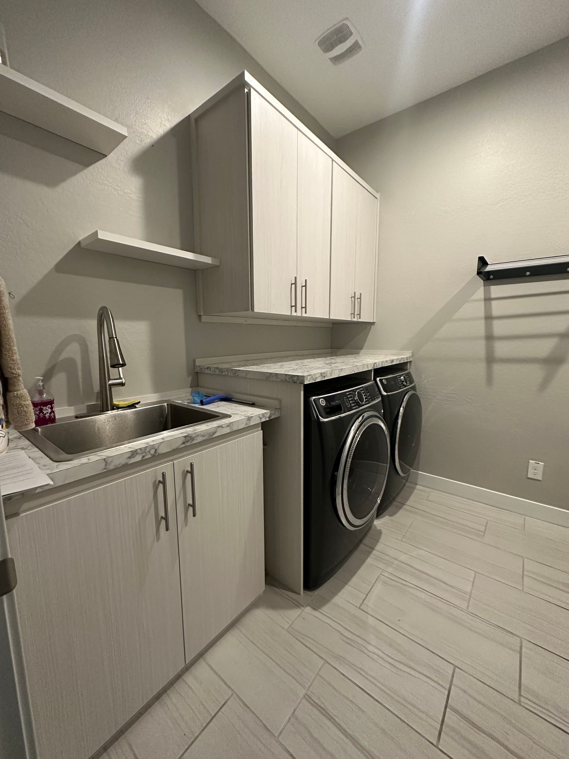 A laundry room with a washer and dryer and a sink