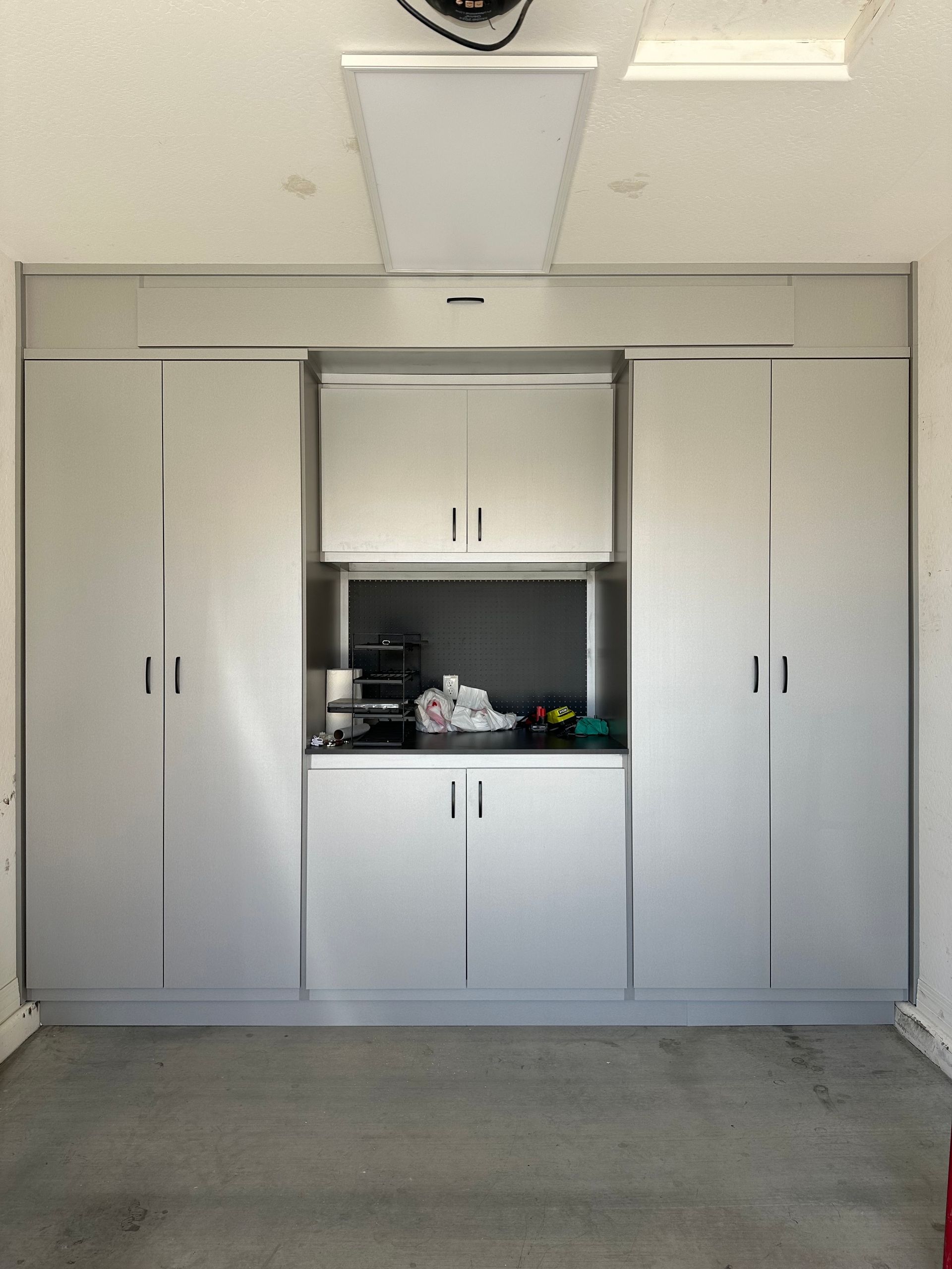 A garage with white cabinets.
