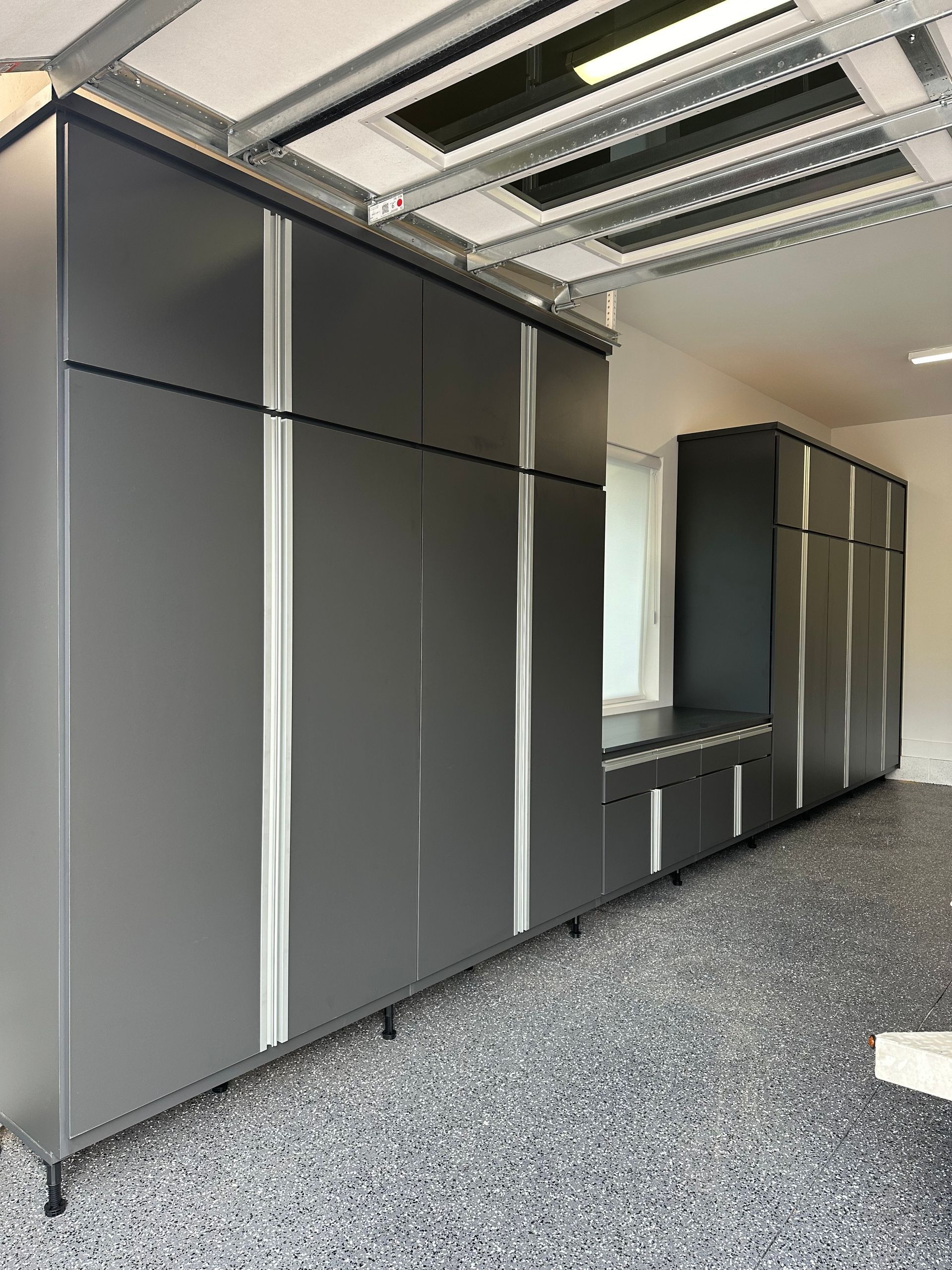 A garage with a lot of cabinets and a gray floor.