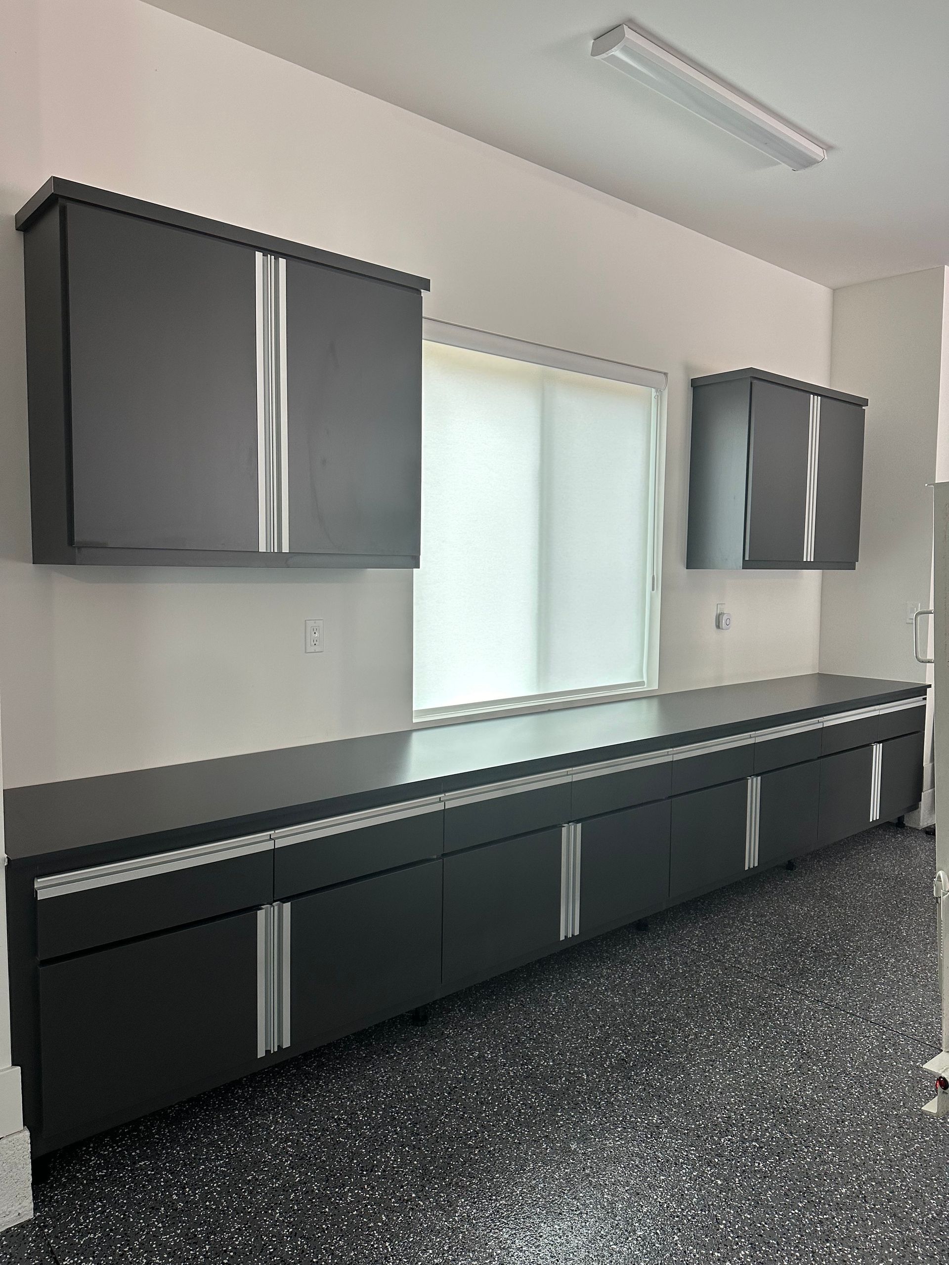 A kitchen with black cabinets and a black counter top.