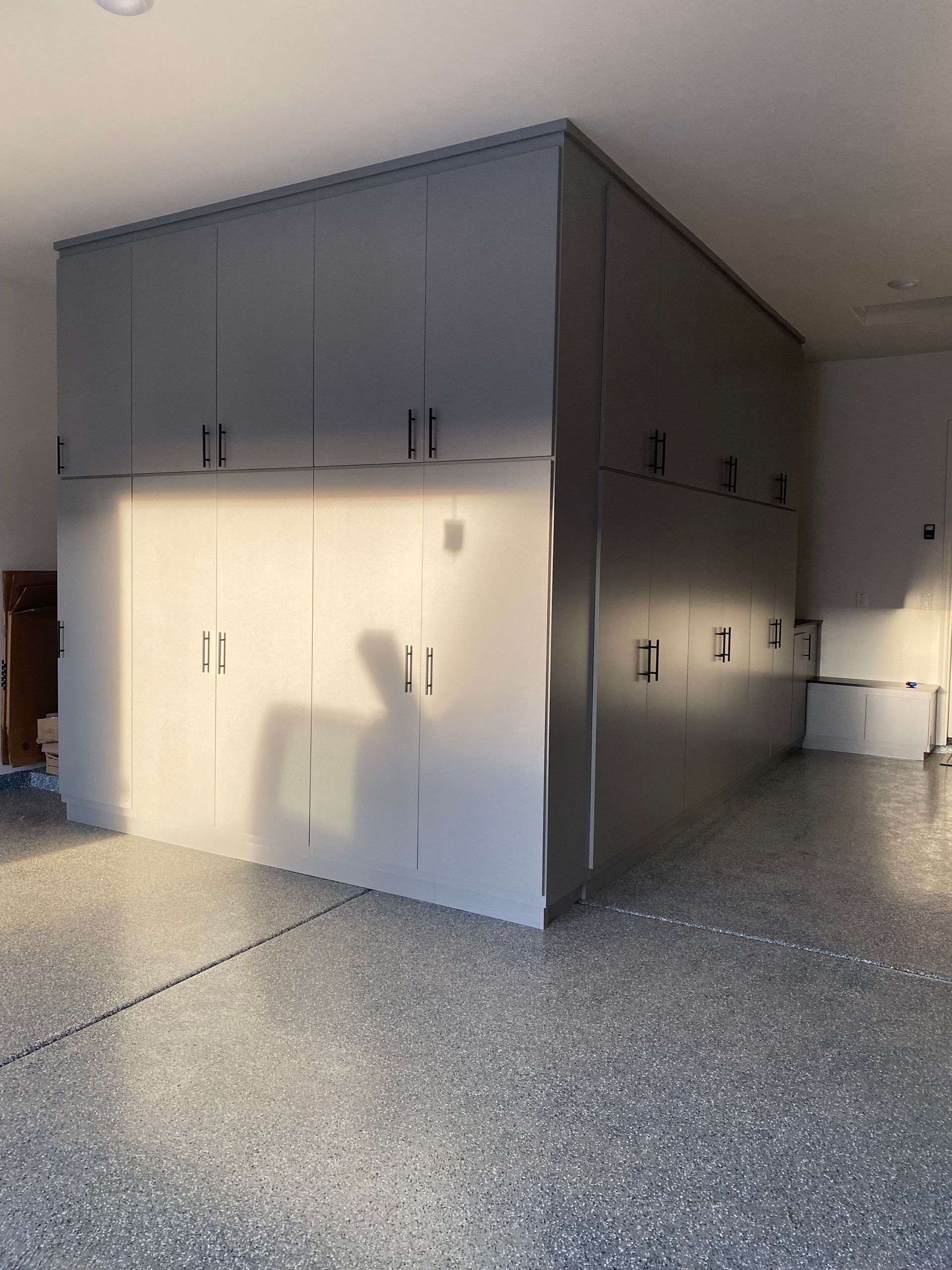 A large room with a lot of cabinets and a shadow of a person on the wall.