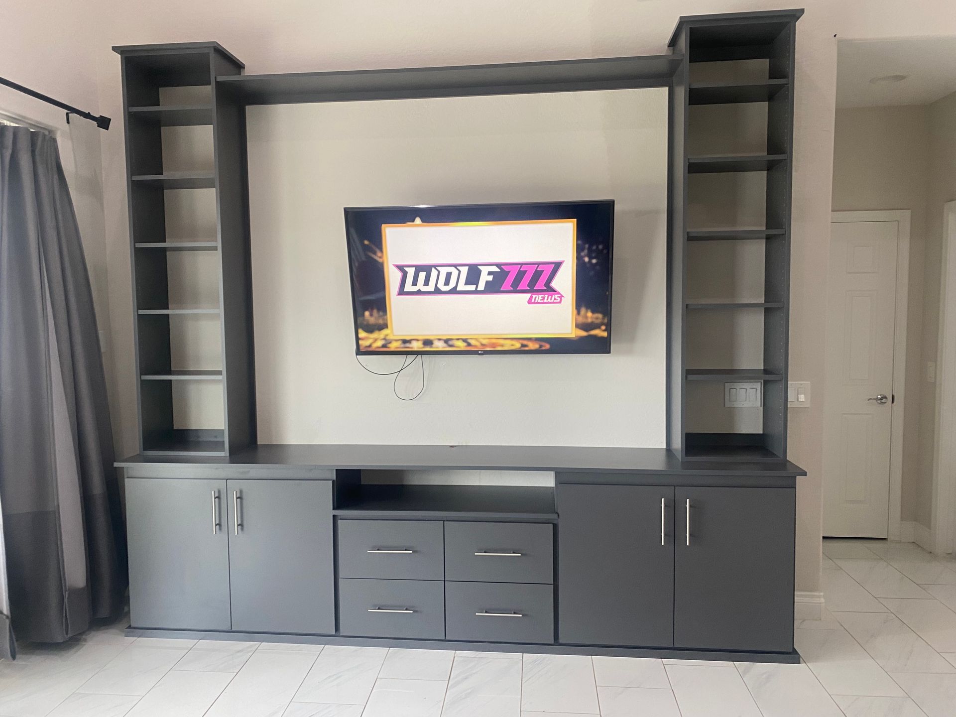A tv on a wall that says wolf fm on it